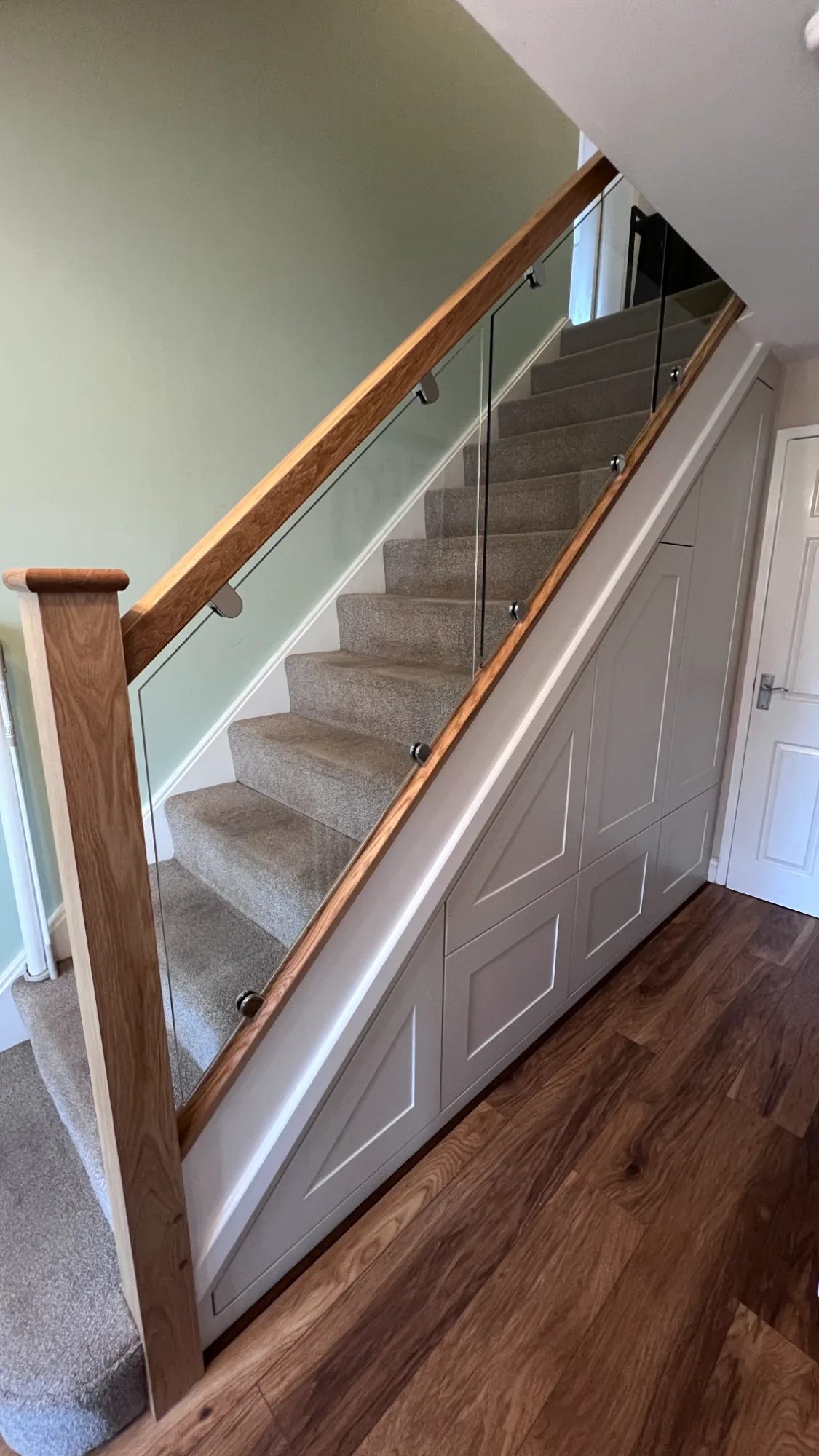 Oak and glass balustrade staircase with understairs storage